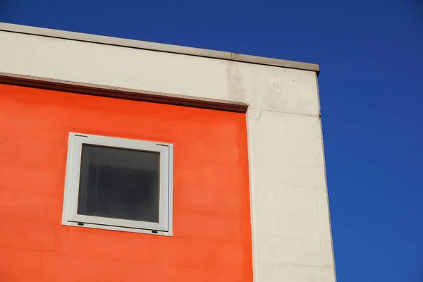 Arquitetura. Fachada vermelha de um edifício com janelas. fachada colorida — Fotografia de Stock