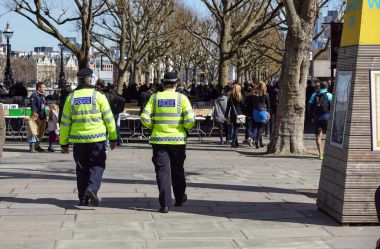 Londra, İngiltere - 22 Nisan 2017:: Westminster bölgesinde kaldırımda yürüyen Londra polis