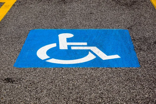 Disability symbol painted on the floor at parking lot — Stock Photo, Image