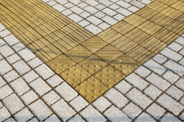 Sidewalk guides for blind. Yellow concrete cobblestones on walkway for blindness people — Stock Photo, Image