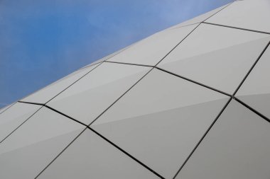 Sandviç panel mavi gökyüzü arka plan üzerinde yapılmış modern bir binada dairesel bir cephe detay.