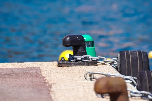 Old metal dock mooring pole with ring and rope for securing fishing boats — Stock Photo, Image