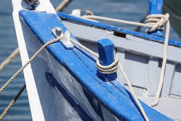 Csomózott kék kötelet egy régi fából készült hajó oldalától megállapításáról — Stock Fotó