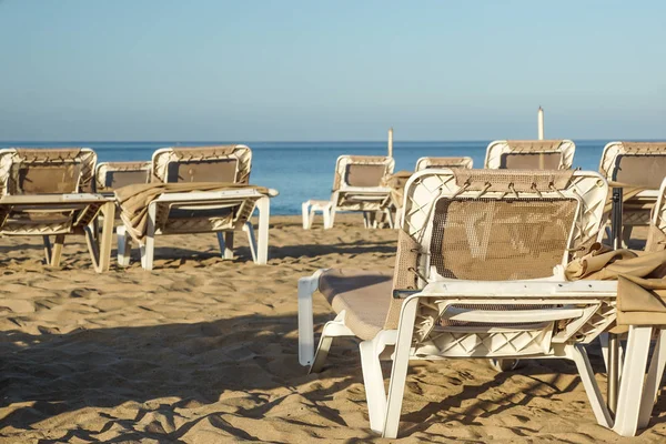 Chaises longues et parasols fermés dans une station balnéaire, l'atmosphère calme et détendue des vacances d'été — Photo