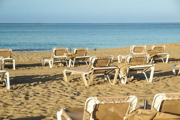 Chaises longues et parasols fermés dans une station balnéaire, l'atmosphère calme et détendue des vacances d'été au coucher du soleil — Photo