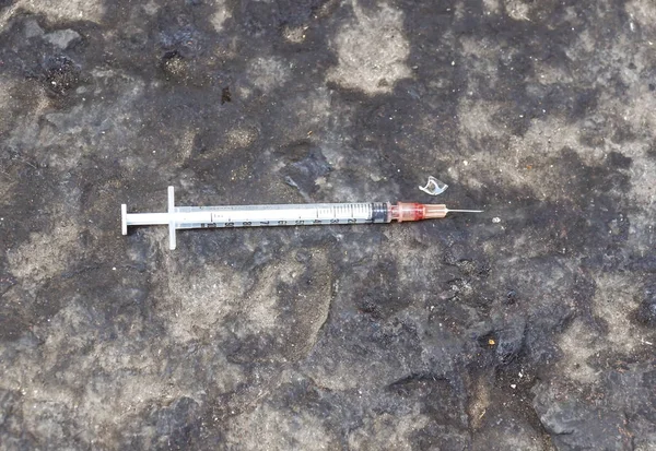 Substance abuse, addiction and drug use concept - close up of used syringes on ground Stock Photo