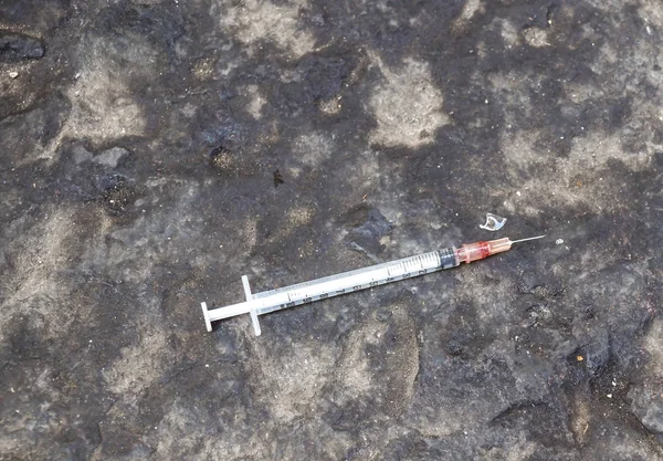 Substance abuse, addiction and drug use concept - close up of used syringes on ground Royalty Free Stock Images