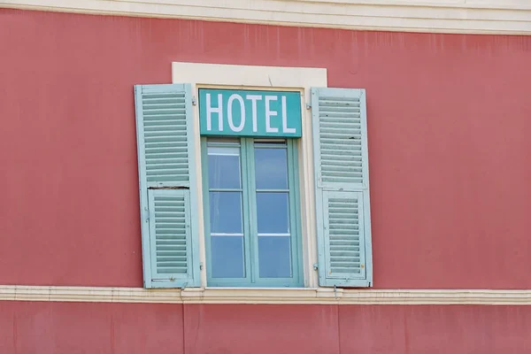 hotel signboard in a building facade with windows