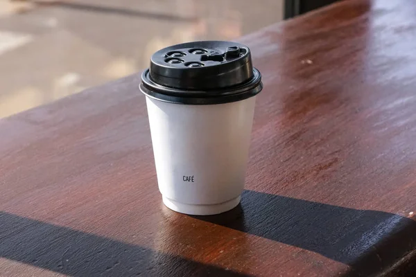 Filiżanka kawy papieru z kawiarni na drewniane tła — Zdjęcie stockowe