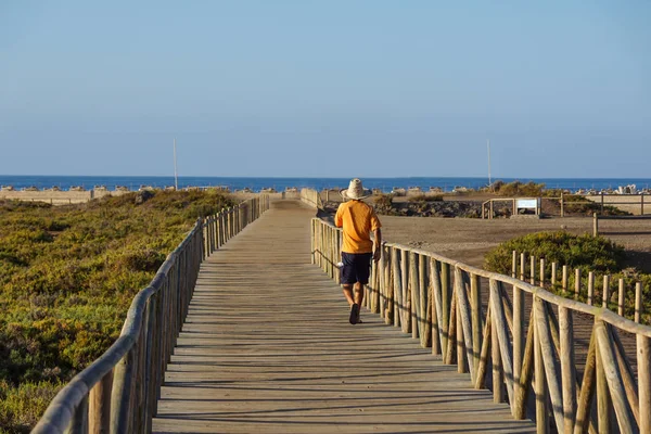 Folk som kör i en dune gångväg nära havet i solnedgången — Stockfoto