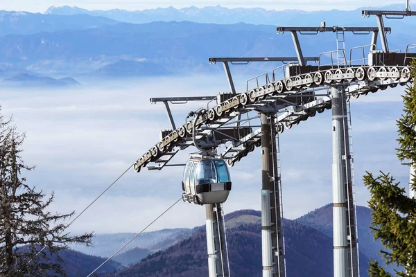 Ski lift cable booth or car, Ropeway and cableway transport sistem for skiers with fog on valley background