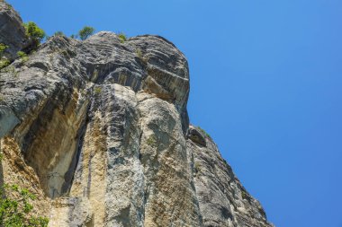 mavi gökyüzüne kadar uzanan bir dağın kayalık duvar .