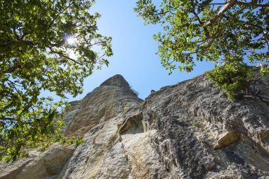 mavi gökyüzüne kadar uzanan bir dağın kayalık duvar .