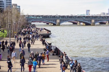 Londra, Birleşik Krallık-6 Nisan 2017: turistler, güneşli bir bahar gününde Thames nehrinin güneyinde yer alan ağaçta yol kaplı .