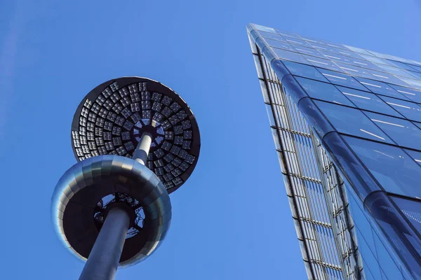 Lamp post in front of a Glass and concrete facade on a modern corporate skycraper building