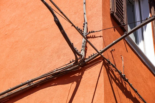 電力ケーブル 電話ケーブル および古い建物ファサードの前に金属の水道管 — ストック写真
