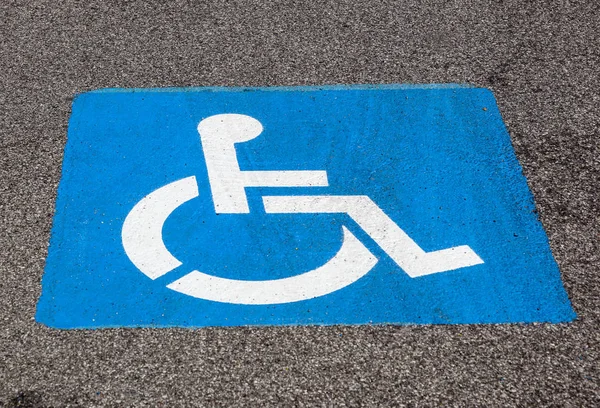 Símbolo de deficiência pintado no chão no estacionamento — Fotografia de Stock