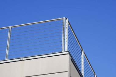 Mavi gökyüzünün beyaz korkuluk balkon