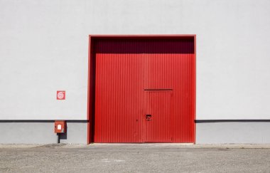 Sac metal fabrika duvar Endüstri Parkı içinde kırmızı giriş kapısı ile. Kırmızı kapıyı fabrika binası.