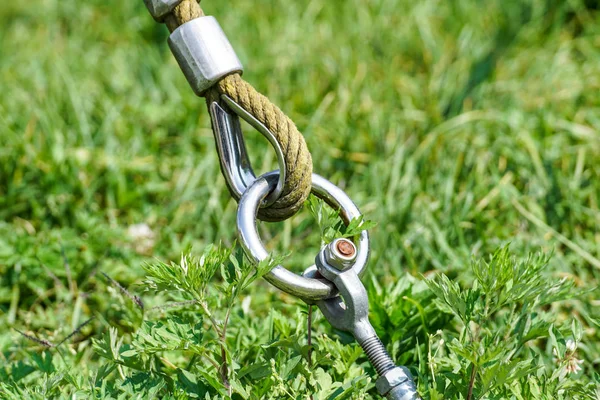 Slutet av swinging repet hänga på metall konstruktion i en park. Grova rep slutet i metall cirklar och säkerhet snapin krok — Stockfoto