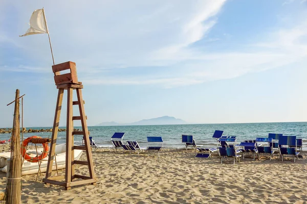 Signe d'avertissement d'un drapeau de wite sur une belle plage avec un ciel bleu au coucher du soleil — Photo