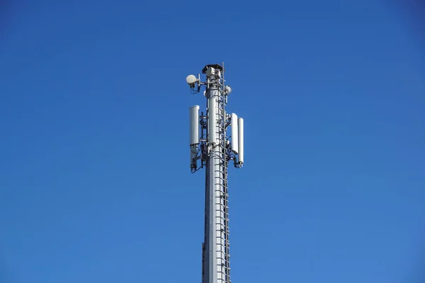 Tecnologia no topo da antena de torre GSM 4G de telecomunicações, transmissor, céu azul, nuvens brancas . — Fotografia de Stock