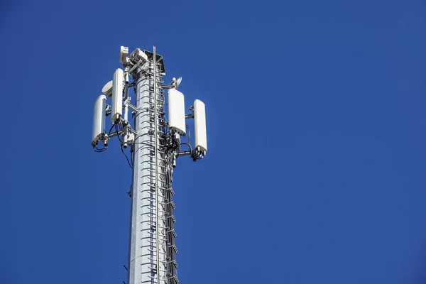 Τεχνολογία στην κορυφή η κεραία Πύργος τηλεπικοινωνιών Gsm 4 g, πομπός, μπλε του ουρανού, λευκά σύννεφα. — Φωτογραφία Αρχείου
