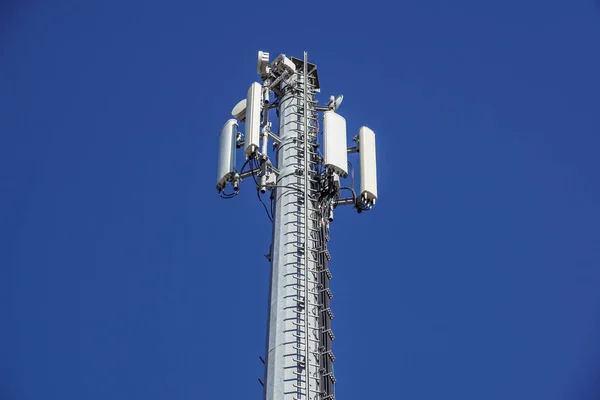 Teknik på toppen av den telekommunikation Gsm 4 g tower antenn sändare, blå himmel, vita moln. — Stockfoto