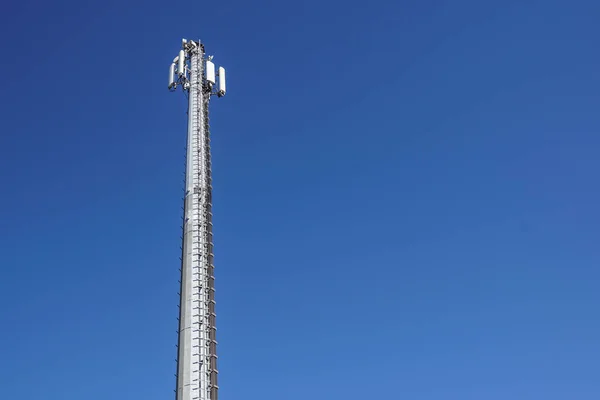 Τεχνολογία στην κορυφή η κεραία Πύργος τηλεπικοινωνιών Gsm 4 g, πομπός, μπλε του ουρανού, λευκά σύννεφα. — Φωτογραφία Αρχείου
