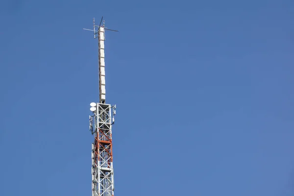 Torre da antena da comunicação do telefone móvel com antena parabólica no fundo azul do céu, torre da telecomunicação — Fotografia de Stock