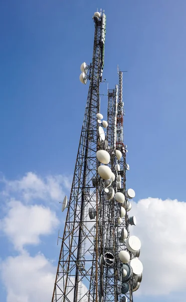 Антенны телекоммуникационных мачт TV беспроводной технологии с голубым небом утром — стоковое фото