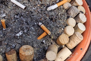 Birçok sigara izmaritleri kirli kül tablası içinde. Bir sürü sigara izmaritleri. Akciğer kanserinin nedeni. Bir sürü çöp olarak kullanılan sigara izmaritleri.