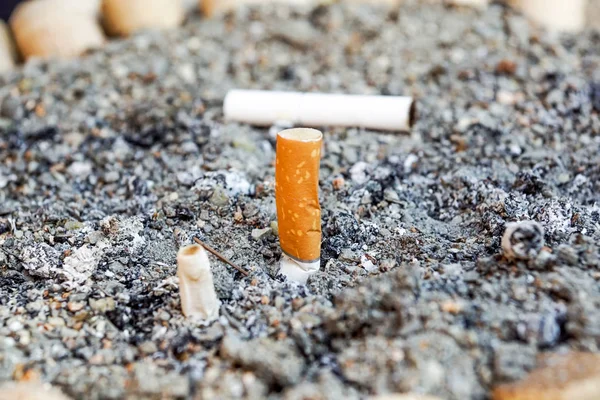 Muchos colillas de cigarrillos en el cenicero sucio. Un montón de colillas de cigarrillos. Razón del cáncer de pulmón. Un montón de colillas de cigarrillos usados como basura . — Foto de Stock