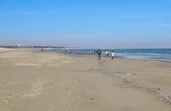 Familie van vier handen vasthouden en wandelen op het strand — Stockfoto