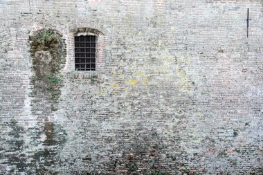 Metal parmaklıklarla kilitlenmiş antik tuğla duvar ve pencere