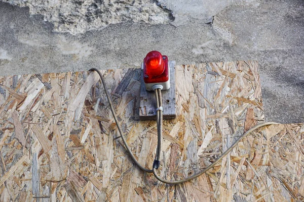 Jasnoczerwona lampa budowlana oświetlona ogrodzeniem w tle przy wejściu na plac budowy — Zdjęcie stockowe