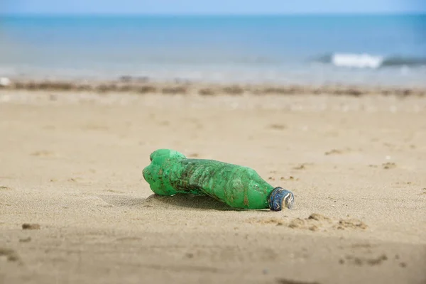 Afval van plastic fles op zand. Vuilnis op het strand — Stockfoto