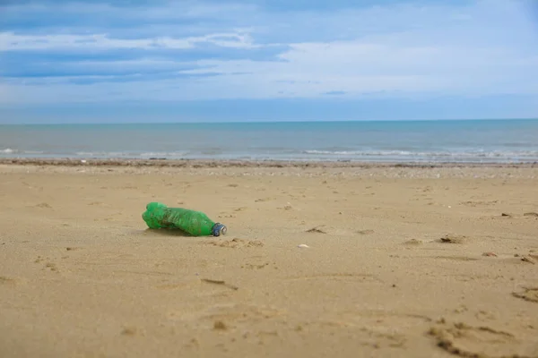 Afval van plastic fles op zand. Vuilnis op het strand — Stockfoto