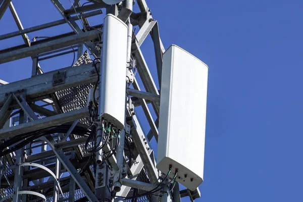 Закрыть белый цвет антенны ретранслятора башня на голубом небе — стоковое фото