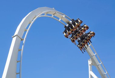 Lunapark trenine bin ve mavi gökyüzüne doğru dön
