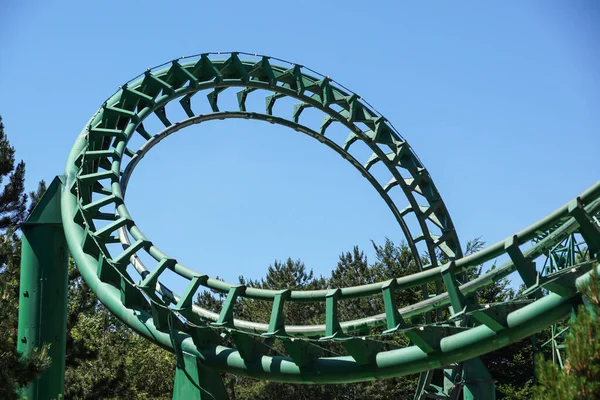 Loop and turn on a green roller coaster in an amusement park Royalty Free Stock Photos