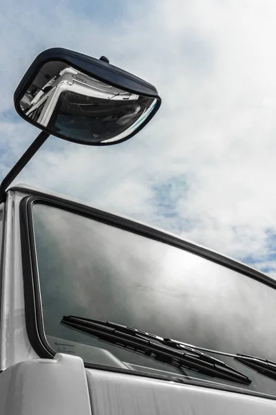 De lucht wordt weerspiegeld in de voorruit van de vrachtwagen — Stockfoto