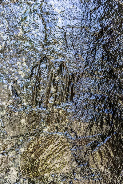 El agua fluye sobre una pared de piedra elevada —  Fotos de Stock