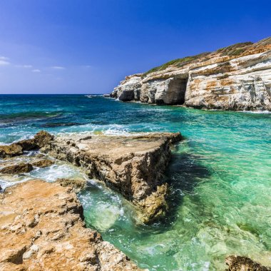 Kıbrıs Adası'nın sarp kıyısı sadece deniz yoluyla erişilebilir küçük mağaralar ile kaplıdır.