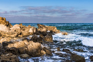 Dalgalar ve Kıbrıs Adası Deniz kıyısında taş döşeme üzerinde kırma sprey.