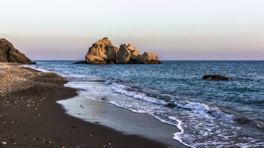 Batan güneşin son ışınları Aphrodite Bay Kıbrıs sahil çevresinde kırmızı dağlar boyalı.