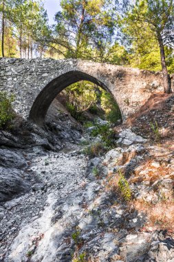 Batan güneşin son ışınları antik taş kemer Troodos dağ orta kısmında Venedik köprü aydınlatılmış.