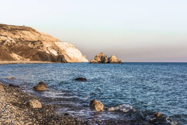 Batan güneşin son ışınları Aphrodite Bay Kıbrıs sahil çevresinde kırmızı dağlar boyalı.
