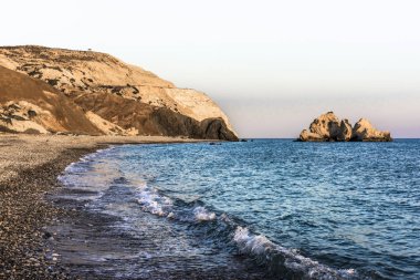 Batan güneşin son ışınları Aphrodite Bay Kıbrıs sahil çevresinde kırmızı dağlar boyalı.