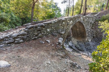 Batan güneşin son ışınları antik taş kemer Troodos dağ orta kısmında Venedik köprü aydınlatılmış.